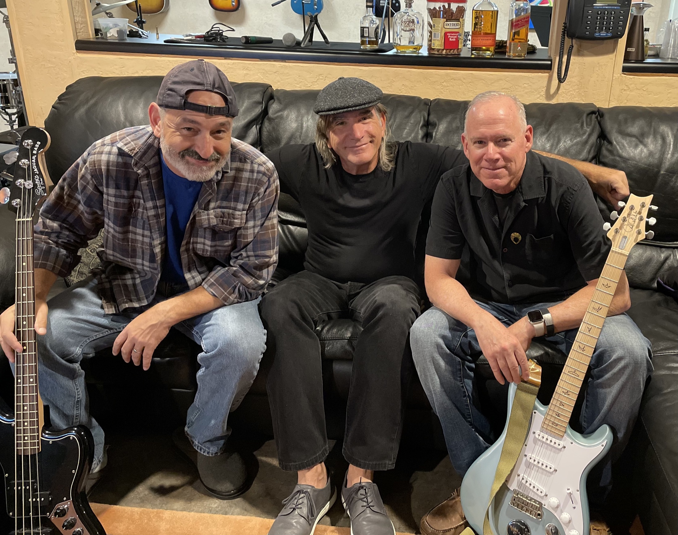 The three members of Almost Dead Jazz with a bass and guitar